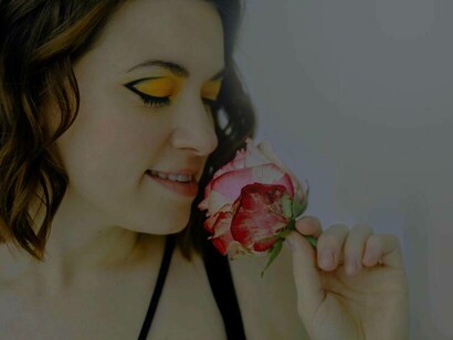 A woman smelling a rose and having a vision from her past
