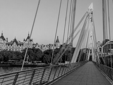 People walking across the Golden Jubilee Bridge in London, UK