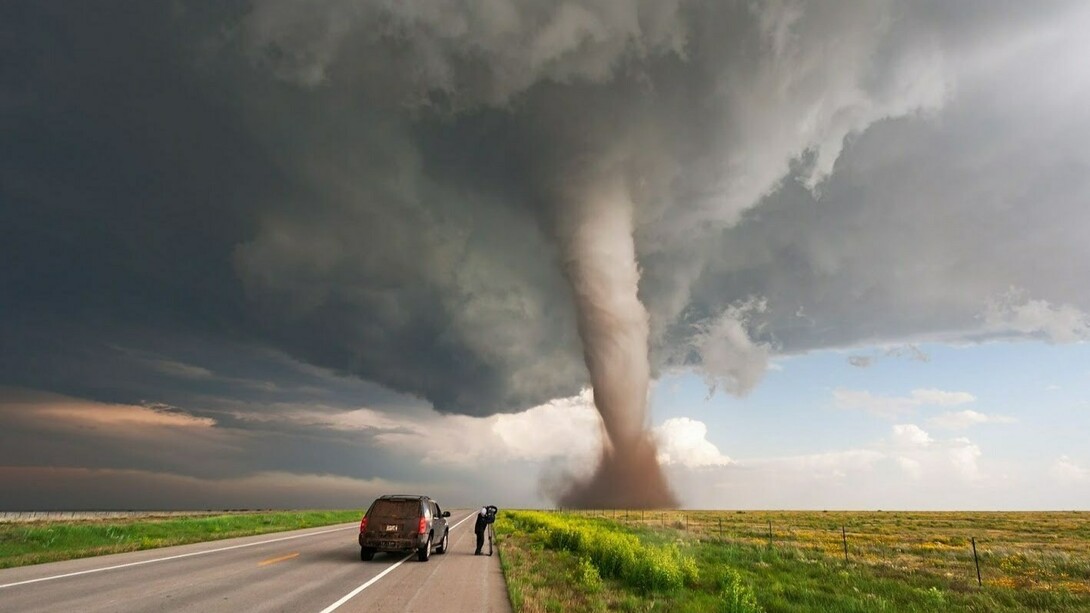 Un cámara filma un tornado en una carretera desierta