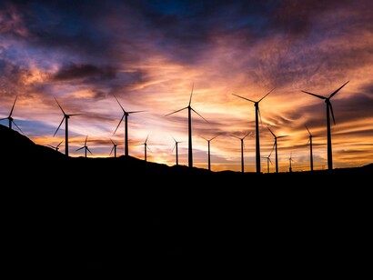 Win turbines stand beautifully on a European hill