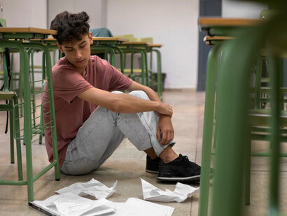 A student feeling overwhelmed and exhausted in the classroom, struggling with burnout