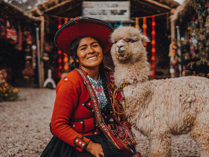 Donna con un alpaca e con abiti tradizionali in  Chinchero, Cuzco, Perù