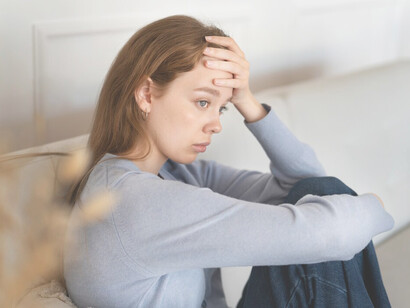 Anxious woman sitting on couch