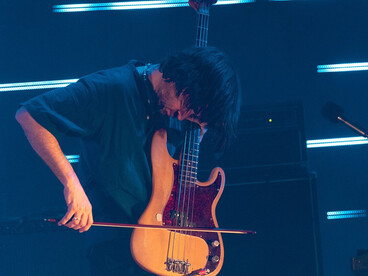 Greenwood is not trying to play bass “normally”: he’s using it like a sound-design instrument to expand what rock music can sound like