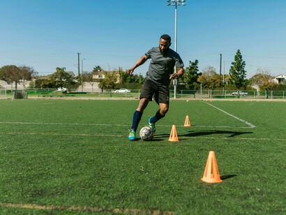 Player trains with agility cones during a soccer drill emphasizing preparation for unexpected challenges 