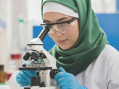Uma cientista realizando pesquisas meticulosamente, utilizando um microscópio no ambiente controlado de um laboratório