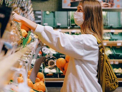 A woman food shopping at the supermarket has decided to purchase a good amount of produce