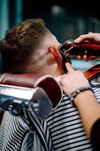 A barber refining a man's appearance with precision, reflecting the idea that attractiveness extends beyond natural features