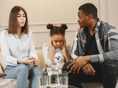 Parents and their little child participate in a family therapy session focused on trauma recovery and emotional support
