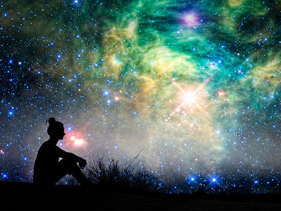 Silhouette of a woman sitting outdoors beneath a star-filled night sky