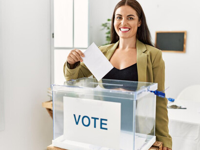 A woman addressing supporters in a political campaign room, embodying the principles of voting, democracy, and representation