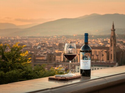 A rustic wall in a Tuscan town frames an offering of wine and food, a nod to the city's unique and historical wine windows