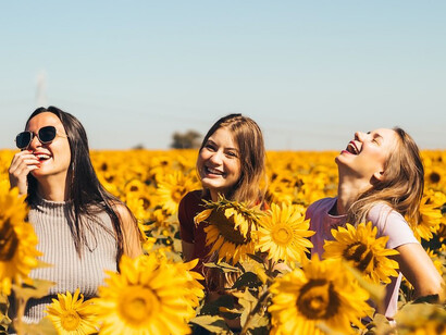 Women standing on yellow sunflower field during daytime