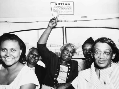 A passenger points to one of the segregation signs removed from all Dallas Transit Company buses, following a Supreme Court ruling banning segregation on all public transportation within a state, on April 25, 1956