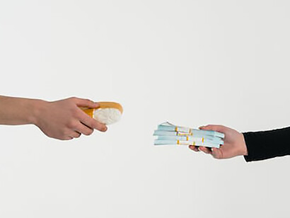 Two hands in stark opposition: one proffering money, the other presenting prohibited drugs, capturing a moment of choice and consequence
