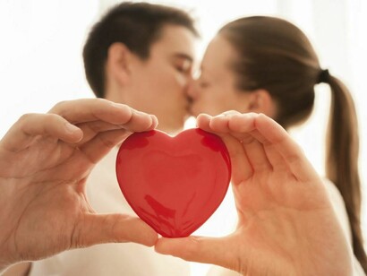 Una pareja sosteniendo un corazón de caramelo