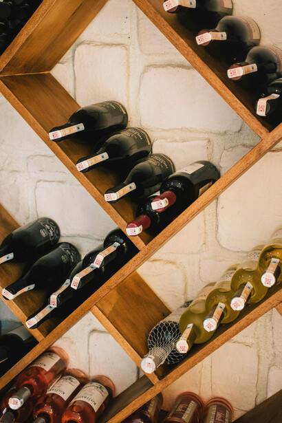 Wine bottles arranged on a brown wooden shelf