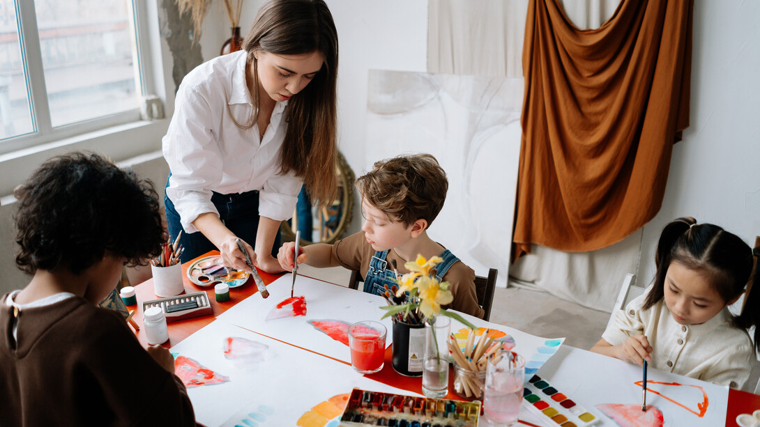 Professora auxilia projeto de pintura dos alunos