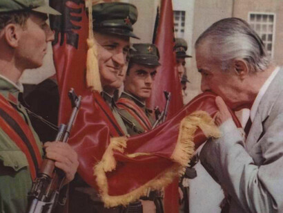 Enver Hoxha (right) kissing the Albanian flag; he ruled the country from 1944 until his death in 1985
