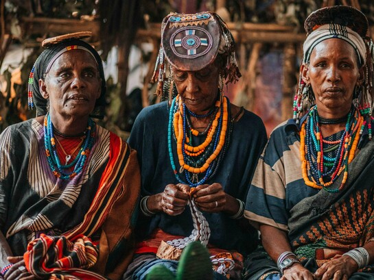 Three women in traditional dress, capturing the intersection of identity, labour, and resilience