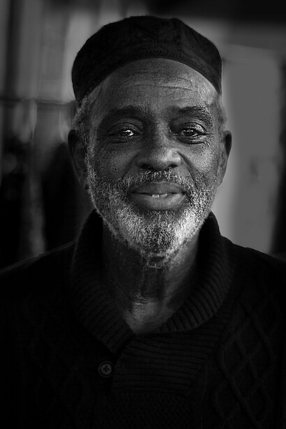 A man wearing a black top looking at the camera