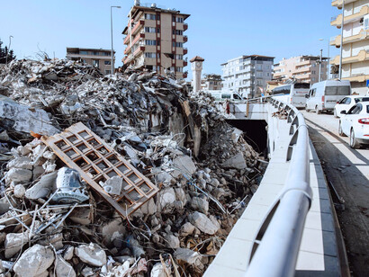 Fragments of concrete and twisted remains, symbolising the weight of forces beyond human control