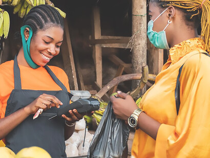 An African woman selling fruits in a vibrant market, reflecting economic activity and commerce in Africa