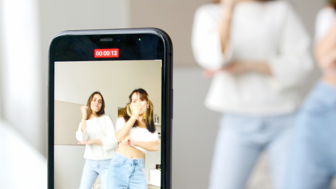 Jovens amigas dançam para vídeo no celular que depois será postado nas redes sociais