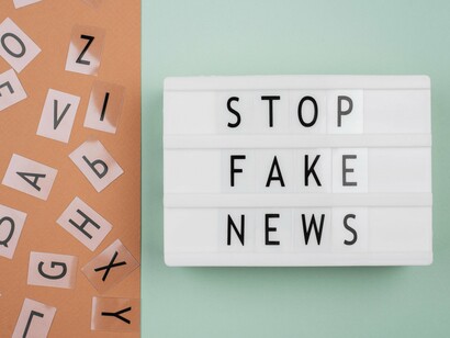 A backlit sign reading “Stop fake news,” symbolising the need for factual integrity in an era of viral content