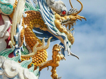 A colorful dragon statue rises against a clear sky in Thailand, inspired by Naga serpent mytholog