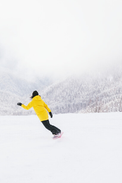 Snowboarding down the snow-covered hill because the woman has the confidence to do it