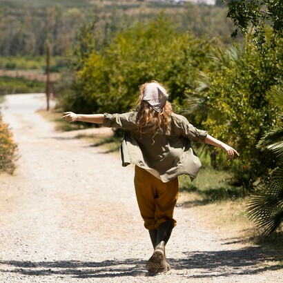 Figura intera di donna che cammina all'aperto: "Nella parola *mèthodos* si annida la parola *hodós*, che voleva appunto dire via, strada, cammino e anche viaggio, gita, marcia"