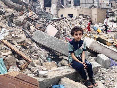 Joven palestino sentado sobre las ruinas de Gaza