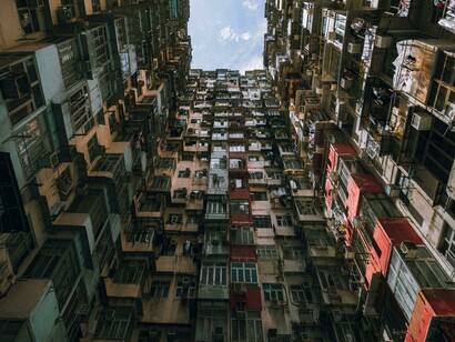 A low-angle view of a crowded residential building in Hong Kong, capturing the realities of urban density, economic inequality, and hidden poverty