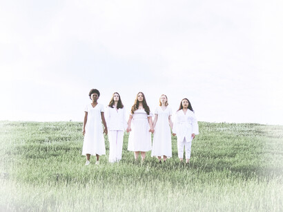 The five women in white, holding hands in togetherness