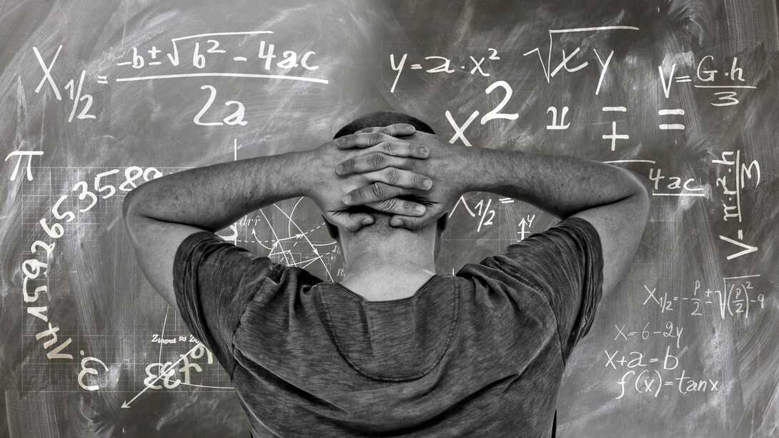 A student staring at the problem on the board at his university, unsure of the answer