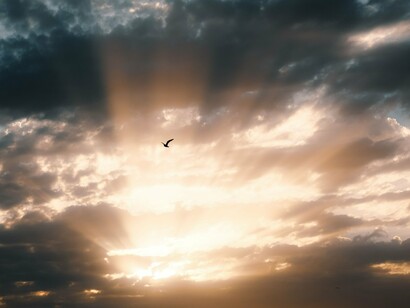 A luz do sol rompe a formação de nuvens densas no céu. Assim como a claridade que surge entre as sombras, a busca pela verdade pode atravessar as convenções que tornam a realidade mais confortável e previsível