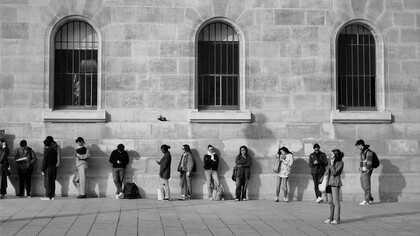 People standing outside a public office with no visible progress, showing  the hidden economic cost of lost time