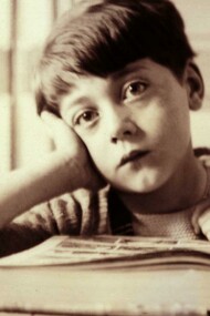 Un niño aburrido frente a un libro de texto