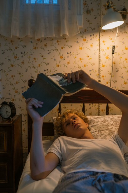Ragazzo adolescente legge un libro nella sua camera da letto