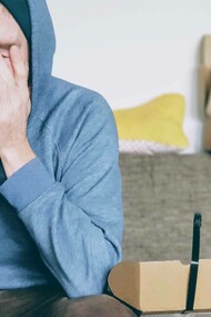 A young person putting their hands to their face because of the amount of stress being experienced