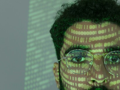 A face reflecting digital surveillance and encrypted data streams reflect Morocco’s use of technology 