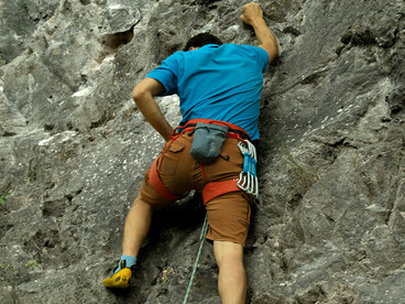 A rock climber steadily climbs a steep cliff in Yalova, Türkiye, embodying concentration and unwavering determination