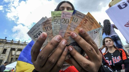 Una venezolana sostiene diferentes billetes de bolívar