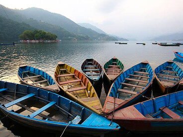 Colorful boats on Phewa Lake in Nepal, a freshwater lake in the Pokhara Valley that spans Pokhara city and extends toward Sarangkot and Kaskikot