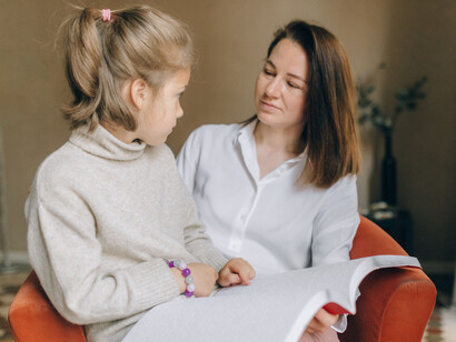 Troca de saberes entre mãe e filha ao compartilharem a leitura de um texto em braile