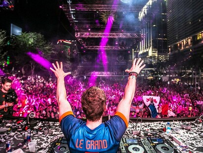 Un DJ saluda al público en un festival de música electrónica