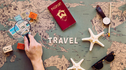 Capture attention with a cropped image of a hand holding a magnifying glass over stamps