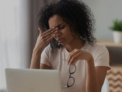 Image of a stressed young businesswoman sitting alone in a dimly lit office 
