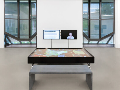 Duty Free Art, Hito Steyerl, 2015, 3-Kanal-Videoinstallation, Farbe, Ton, Metallkiste mit Sand, 38:21 Min Kamera: Christoph Manz.
Courtesy of Andrew Kreps Gallery, New York